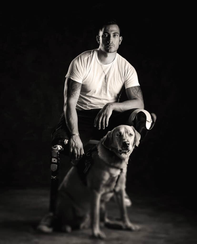 Veteran standing with his Canine Companions service dog