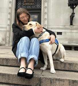 Sofia and Service Dog Trooper seating on the stair in front of the libreary